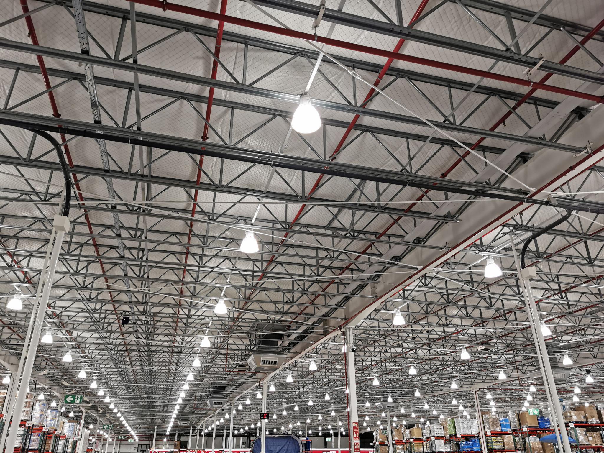 Industrial warehouse interior at night lit by overhead lights. The operating environment where AI either takes root or doesn't